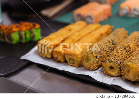 Crispy Fried Sushi Fingers On Paper Tray With Golden Crumb Coating, Batch Cooling Next To Fresh 137894610