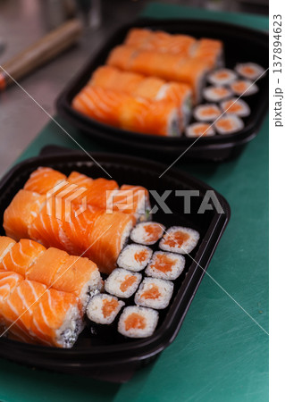 Readytoserve Salmon Sushi Box With Rolls And Maki Neatly Arranged In Black Tray, Compact Takeaway Readytoserve Salmon Sushi Box With Rolls And Maki Neatly Arranged In Black Tray, Compact Takeaway 137894623