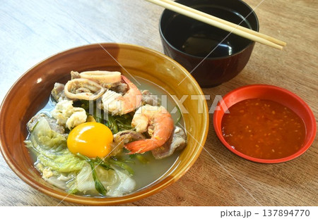 boiled sukiyaki seafood chicken and pork meat couple squid and shrimp with vegetable in soup on bowl dipping sauce 137894770