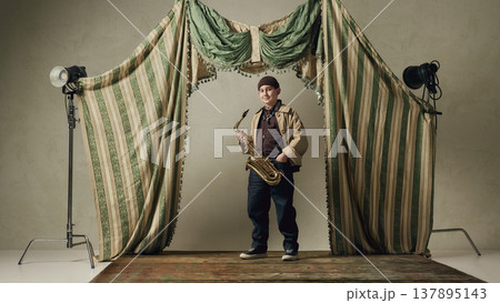 Teen boy holding saxophone on stage confident music portrait jazz style. Teen boy holding saxophone on stage confident music portrait jazz style. 137895143