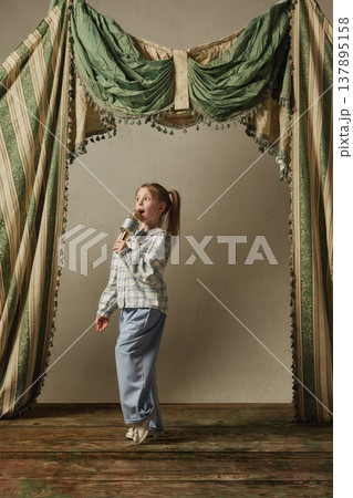 Little girl singing with microphone walking on stage expressive vocal performance 137895158
