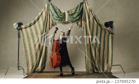 Happy little girl with cello celebrating music performance on stage joyful artistic expression 137895270