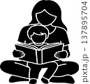 A black silhouette of a mother reading a storybook to her young child, both sitting cross-legged. 137895704