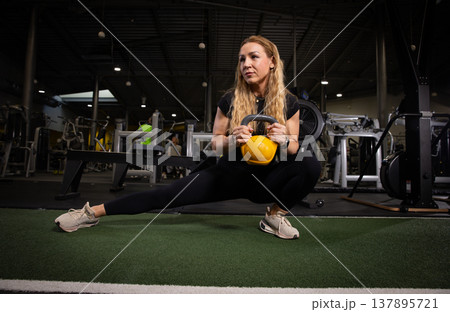 Fitness and health concept. A fit young woman works out in a modern gym. Athletic man doing exercise. Fitness and health concept. A fit young woman works out in a modern gym. Athletic man doing exercise. 137895721