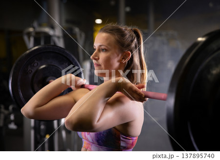 Fitness and health concept. A fit young woman works out in a modern gym. Athletic man doing exercise. Fitness and health concept. A fit young woman works out in a modern gym. Athletic man doing exercise. 137895740