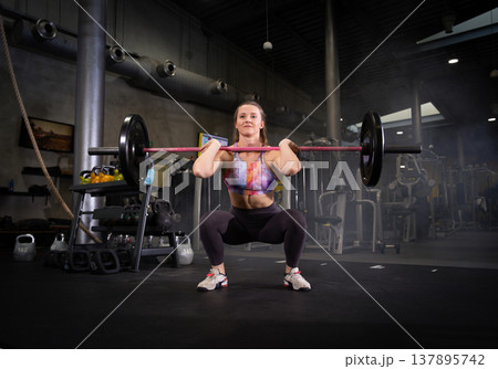 Fitness and health concept. A fit young woman works out in a modern gym. Athletic man doing exercise. 137895742