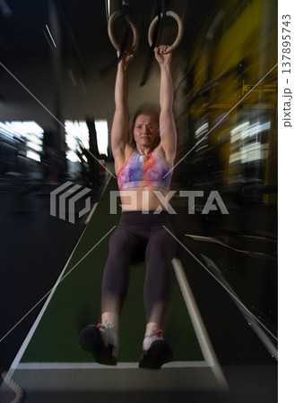 Fitness and health concept. A fit young woman works out in a modern gym. Athletic man doing exercise. 137895743