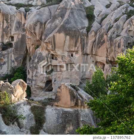Ancient cave dwellings carved into rock formations, Cappadocia, Goreme, Turkey 137895762