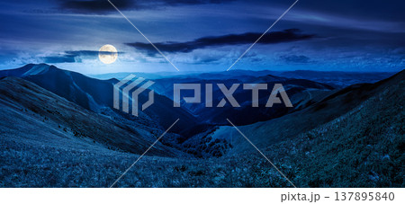 panoramic image of rolling alpine mountain ridge at night. full moon over mysterious summer landscape with hillside meadows under cloudy sky. remote vista with distant valley and forested slopes panoramic image of rolling alpine mountain ridge at night. full moon over mysterious summer landscape with hillside meadows under cloudy sky. remote vista with distant valley and forested slopes 137895840