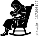 Black silhouette of a mother sitting in a rocking chair, tenderly breastfeeding her newborn baby. 137896197