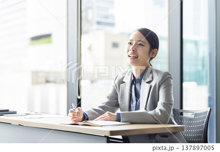 笑顔で勉強をするビジネスウーマン 137897005