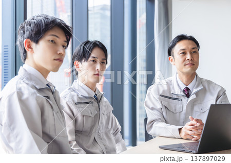 作業着を着て会議に参加するビジネスパーソン 137897029