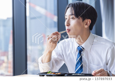 お弁当を食べるビジネスマン 137897033