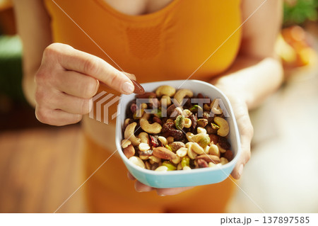 Woman Selecting a Nut from a Nutritious Snack Mix Woman Selecting a Nut from a Nutritious Snack Mix 137897585