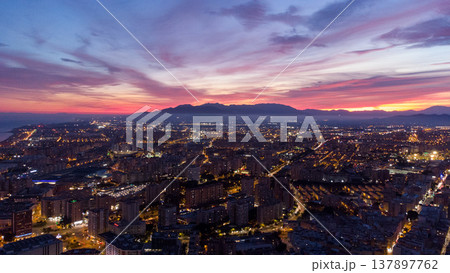 Vibrant Malaga cityscape at dusk with illuminated skyline, iconic tower, and scenic mountainous backdrop. urban, architectural, or travel-themed projects. Malaga Spain Vibrant Malaga cityscape at dusk with illuminated skyline, iconic tower, and scenic mountainous backdrop. urban, architectural, or travel-themed projects. Malaga Spain 137897762