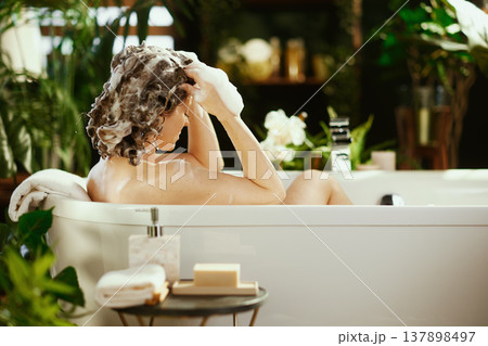 Woman\'s Relaxing Curly Hair Wash in Spa Bathtub 137898497