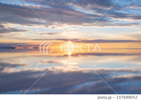 Serene sunset reflection over vast salt flat in Uyuni Bolivia 137899052