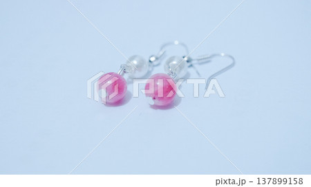 Close-up of handmade earrings for women or girls isolated in white background. Beautiful pearl and pink stones earrings. Fashion and  accessory concepts. 137899158