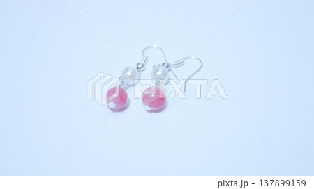 Close-up of handmade earrings for women or girls isolated in white background. Beautiful pearl and pink stones earrings. Fashion and  accessory concepts. 137899159