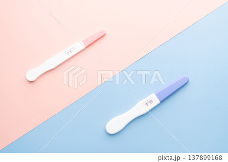 Positive urine pregnancy test on pink and blue background. Pregnancy test kit measure hCG levels in urine. Baby gender concept. Positive urine pregnancy test on pink and blue background. Pregnancy test kit measure hCG levels in urine. Baby gender concept. 137899168