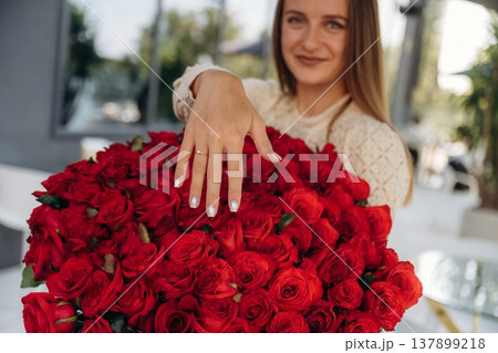 Woman got proposal, showing ring on finger over big bouquet of red flowers Woman got proposal, showing ring on finger over big bouquet of red flowers 137899218