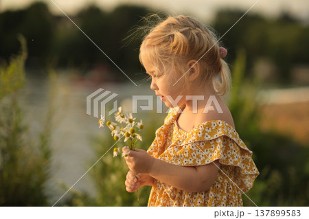 heartfelt smile of girl holding daisies, set against simple park background, advocates for a return to simpler, less materialistic values. benefits of a minimalist lifestyle or simple living. heartfelt smile of girl holding daisies, set against simple park background, advocates for a return to simpler, less materialistic values. benefits of a minimalist lifestyle or simple living. 137899583