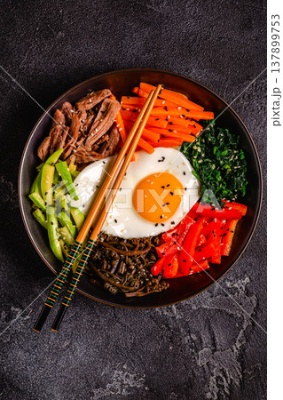 Traditional Korean dish Bibimbap: rice with vegetables beef and egg. 137899753