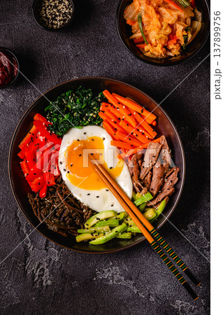 Traditional Korean dish Bibimbap: rice with vegetables beef and egg. Traditional Korean dish Bibimbap: rice with vegetables beef and egg. 137899756