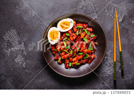 Tteokbokki, Teopokki fried rice cake in black bowl. Tteokbokki, Teopokki fried rice cake in black bowl. 137899855