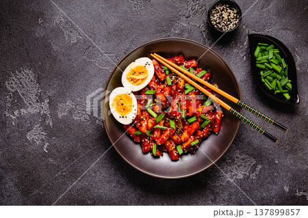 Tteokbokki, Teopokki fried rice cake in black bowl. Tteokbokki, Teopokki fried rice cake in black bowl. 137899857