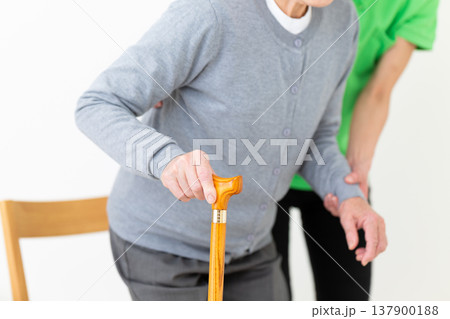 足が悪いお年寄りを介助する介護福祉士 137900188
