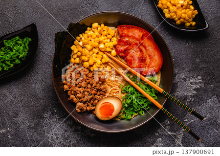 A bowl of ramen with noodles, meat and green onions. 137900691