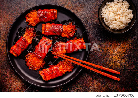 Bacon roll with enoki mushroom grilled with sauce. 137900706