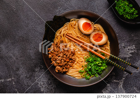 A bowl of ramen with noodles, meat and green onions. 137900724