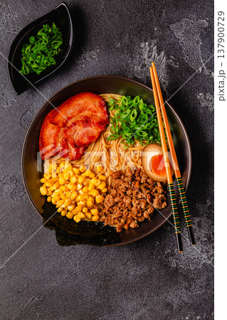A bowl of ramen with noodles, meat and green onions. 137900729