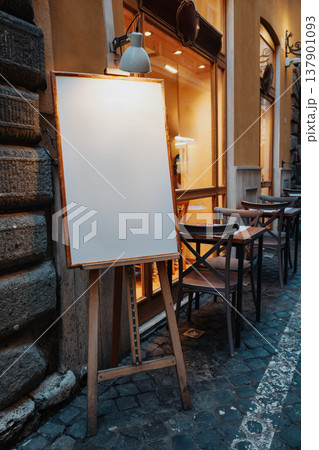 Empty board stands outside a cafe in the early evening near the street Empty board stands outside a cafe in the early evening near the street 137901093