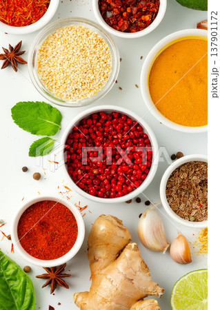 Colorful spices and herbs arranged on a table for cooking in a kitchen setting Colorful spices and herbs arranged on a table for cooking in a kitchen setting 137901172