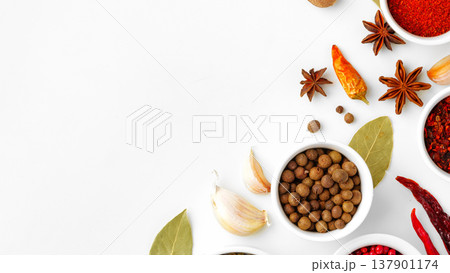 Colorful spices and herbs arranged on a white surface are ready for cooking Colorful spices and herbs arranged on a white surface are ready for cooking 137901174
