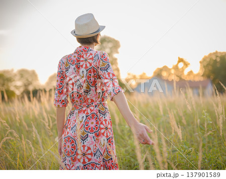 boho chic woman in a floral dress in European countryside 137901589