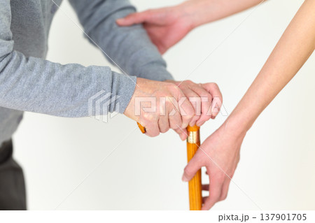 足が悪いお年寄りを介助する介護福祉士 足が悪いお年寄りを介助する介護福祉士 137901705