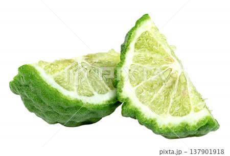 Two fresh slices of green bergamot citrus fruit showing bumpy skin and juicy pulp Isolated. Perfect for food, aromatherapy, or cosmetic concepts. Clean professional macro shot. 137901918