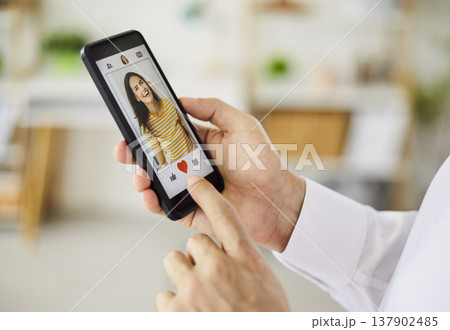 Person using smartphone dating app to like a profile with heart icon closeup Person using smartphone dating app to like a profile with heart icon closeup 137902485