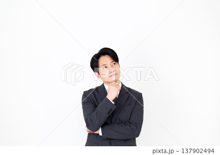 考え事をするスーツを着たミドル男性ビジネスマン 137902494