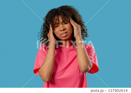 African Teen Girl Suffering Migraine Headache, Blue Studio. Hands On Head African Teen Girl Suffering Migraine Headache, Blue Studio. Hands On Head 137902614