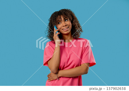 Young African Woman Talking By Cell Phone, Smiling On Blue. Smartphone Call 137902638