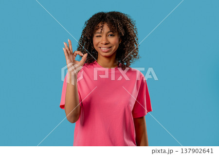 Positive African Teen Girl With Hand Sign Ok, Okay Gesture. Young lady On Blue Positive African Teen Girl With Hand Sign Ok, Okay Gesture. Young lady On Blue 137902641