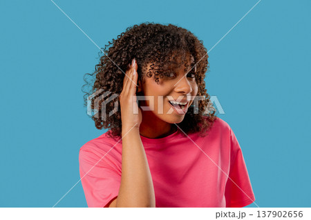 African Girl Pointing To Ear With Confused Face,Signaling She Cant Hear Clearly 137902656