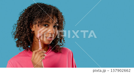 Teenage Girl doing Face Massage with Rose Quartz Stone Roller for Firmer, Smoother Skin. Facial Self Care, Real body, diversity, inclusive, authentic. 137902662