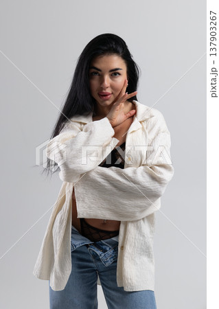 Attractive woman undressing, wearing lingerie and jeans, white studio background 137903267