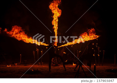 Silhouette Thai performers show fire breathing and spinning on beach 137903847